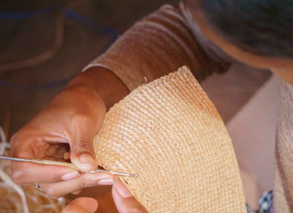une femme qui tresse le raphia